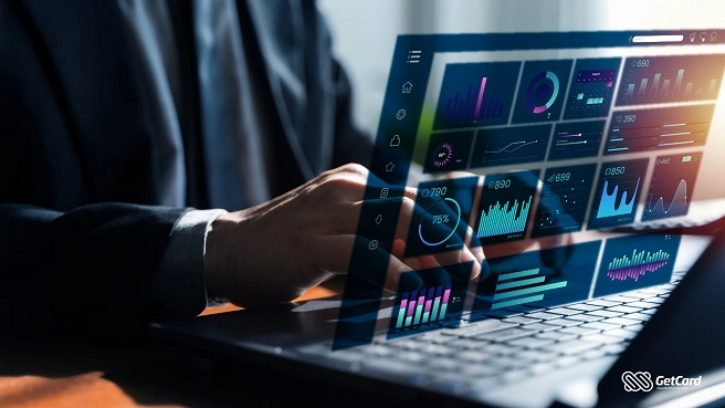 Pessoa de terno usando notebook com interface holográfica de dashboard de dados, gráficos e métricas financeiras.
