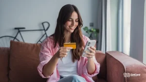 Mulher sorrindo enquanto faz compras online no celular.