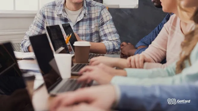 Reunião de equipe com laptops e café na mesa
